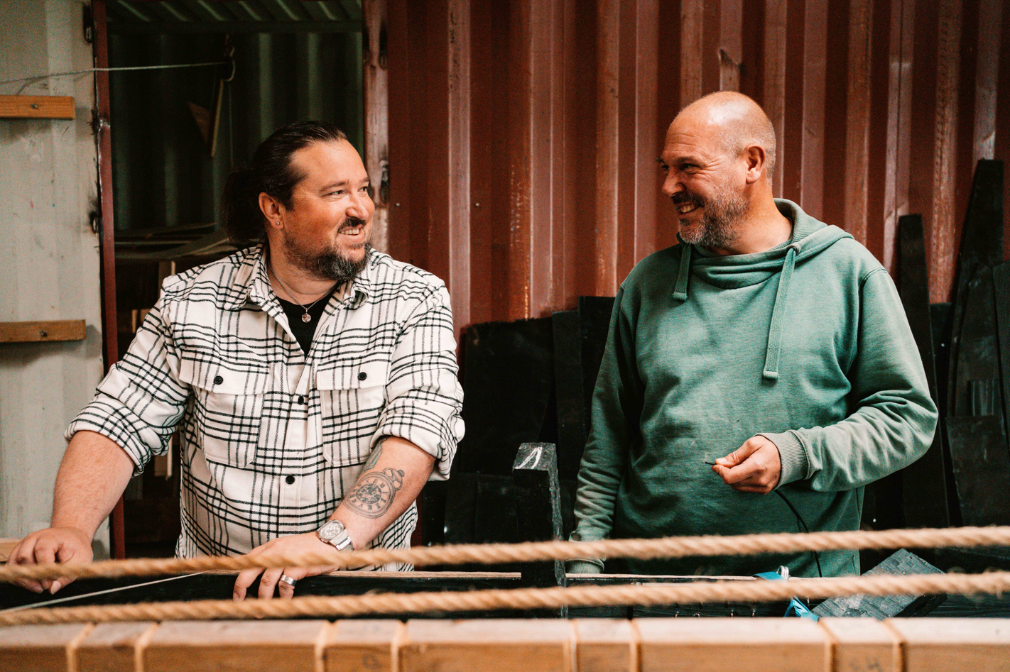 2 mannen lachen naar elkaar, scheepsbouw, op de scheepswerf, 